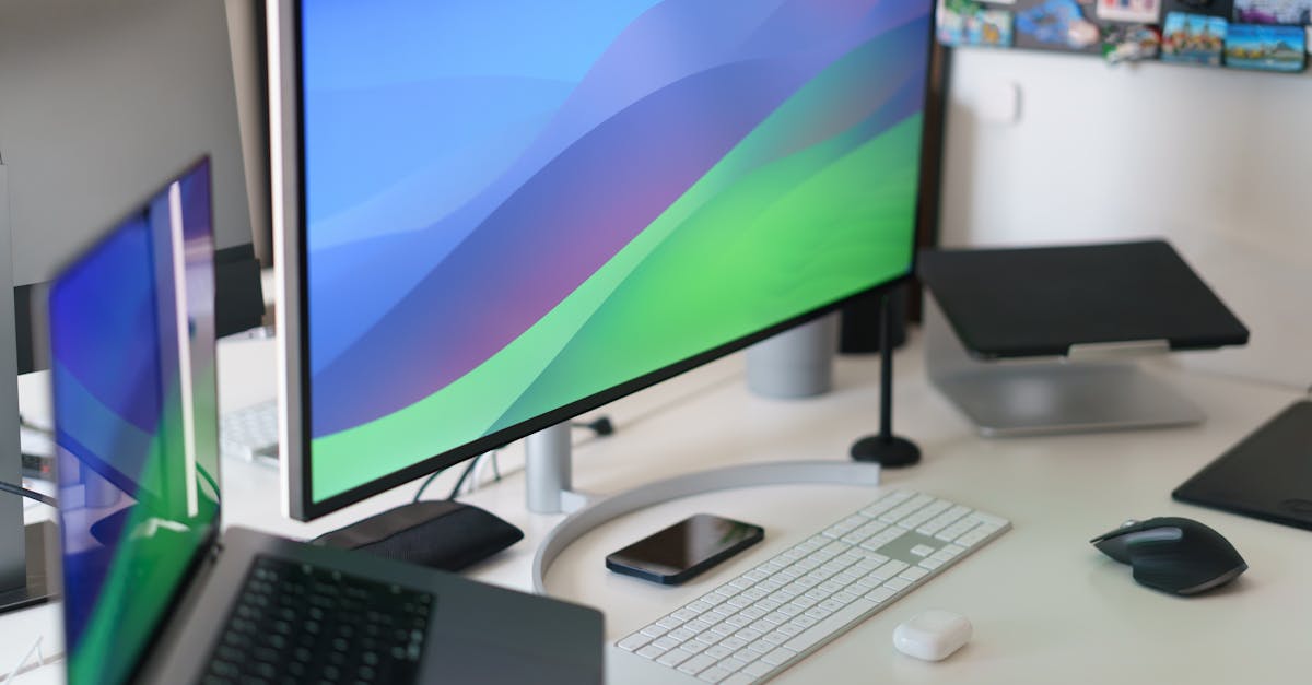 Sleek home office setup with multiple monitors, keyboard, smartphone, and stylish decor.