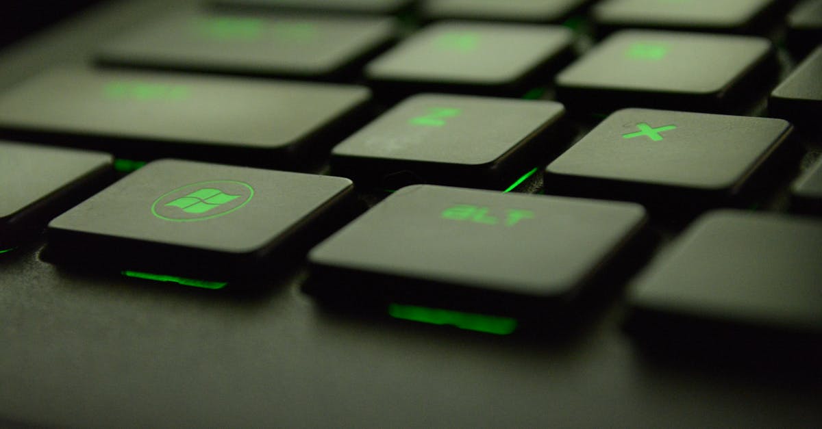 Detailed view of illuminated backlit keyboard keys with green lighting for gaming and tech use.